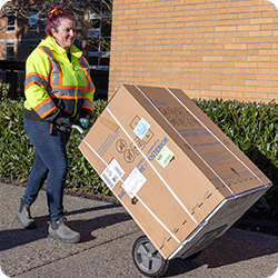 Worker moving a box with a dolly