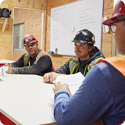 workers sitting at a table having a discussion